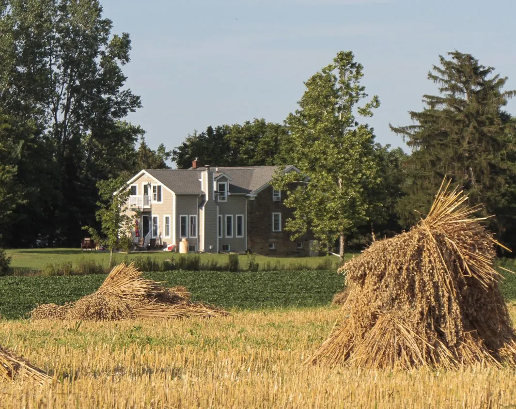 The Old Stone House and its attached home seen across the fields